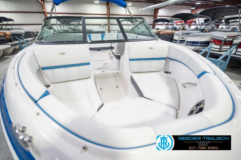 Slide: The Image of 2015 Regal 2000 ESX Bowrider with white and blue interior, displayed in a showroom. - 13