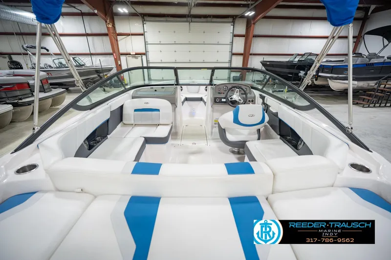 Slide: The Image of 2015 Regal 2000 ESX Bowrider interior with blue and white seating in a showroom. - 16