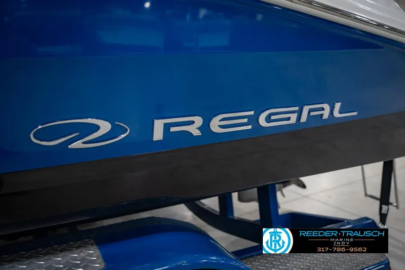 Slide: The Image of 2015 Regal 2000 ESX Bowrider boat, blue hull with logo, displayed indoors. - 50