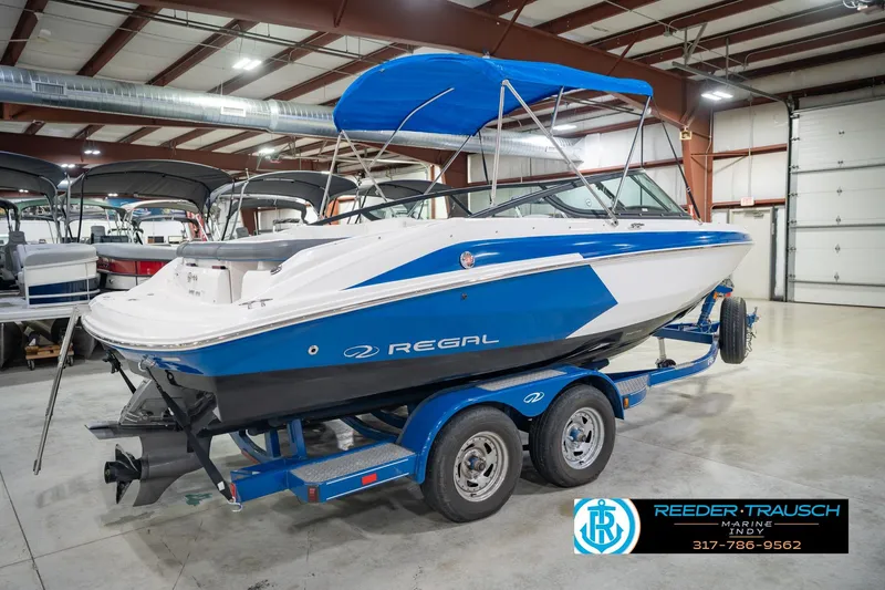 Slide: The Image of 2015 Regal 2000 ESX Bowrider boat with blue and white design in indoor showroom. - 8