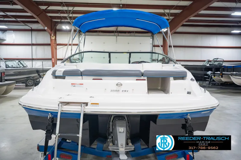 Slide: The Image of 2015 Regal 2000 ESX Bowrider with blue canopy in indoor showroom. - 9