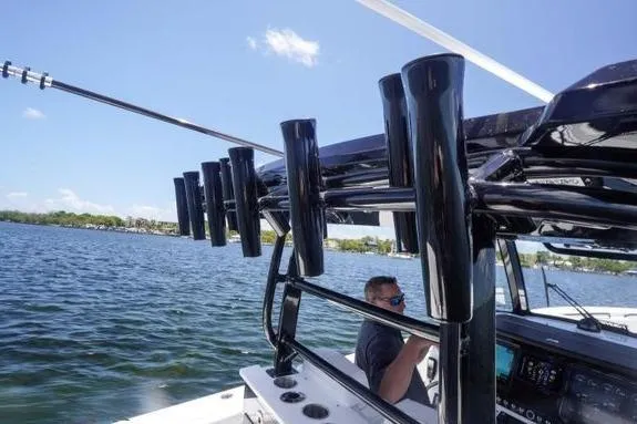 Slide: The Image of 2023 Fountain 38 Tournament Edition boat on water, featuring rod holders and a person at the helm. - 12