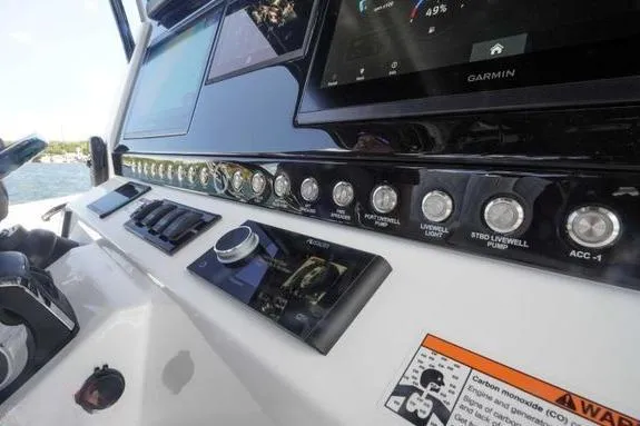 Slide: The Image of 2023 Fountain 38 Tournament Edition boat dashboard with Garmin display and control panel. - 19