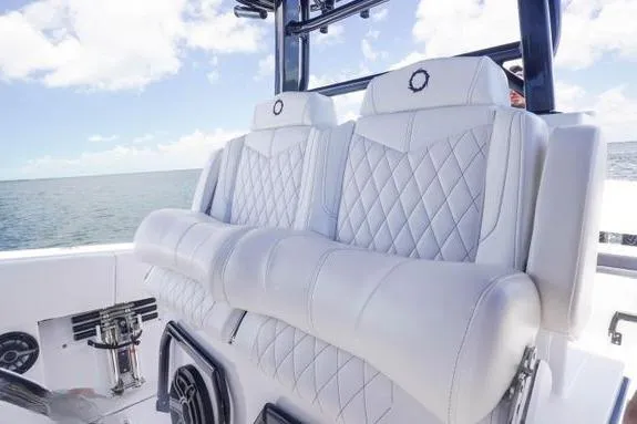 Slide: The Image of 2023 Fountain 38 Tournament Edition boat with luxurious white seating and ocean backdrop. - 28
