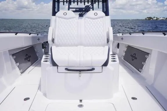 Slide: The Image of 2023 Fountain 38 Tournament Edition boat interior with white seating and ocean backdrop. - 31