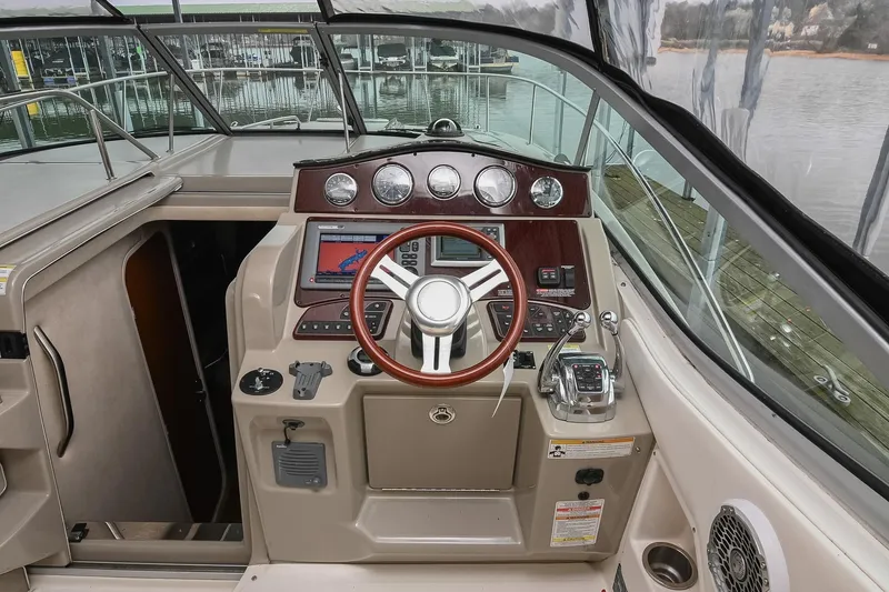 Slide: The Image of Cockpit of 2012 Sea Ray Sundancer 330 with steering wheel and navigation controls. - 23