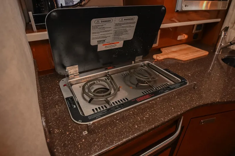 Slide: The Image of 2012 Sea Ray Sundancer 330 interior with open cabinet and drawer, showcasing storage space. - 38