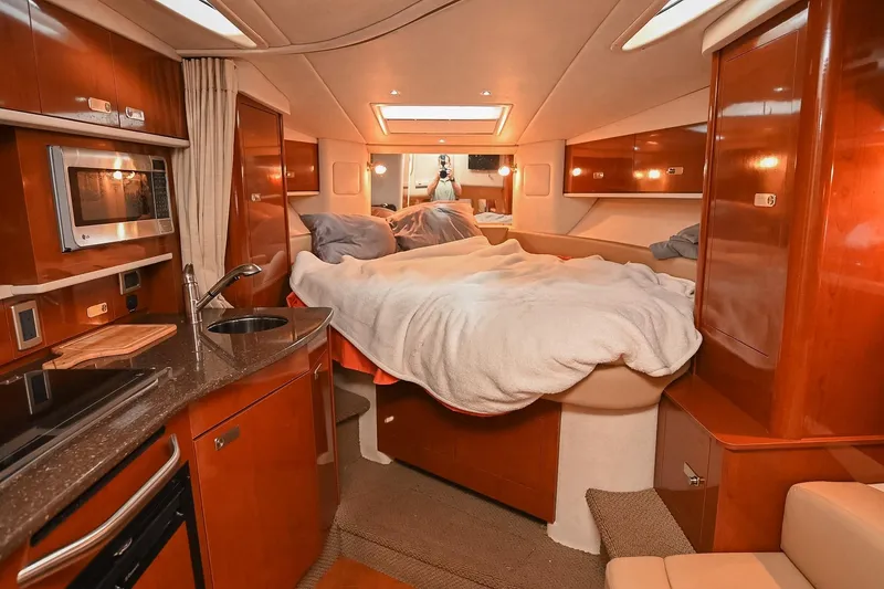 Slide: The Image of Cozy cabin interior of 2012 Sea Ray Sundancer 330 with plush bedding and warm lighting. - 40