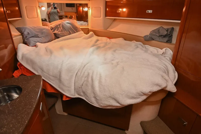 Slide: The Image of Interior cabin of 2012 Sea Ray Sundancer 330 with cozy bedding and wooden cabinetry. - 41