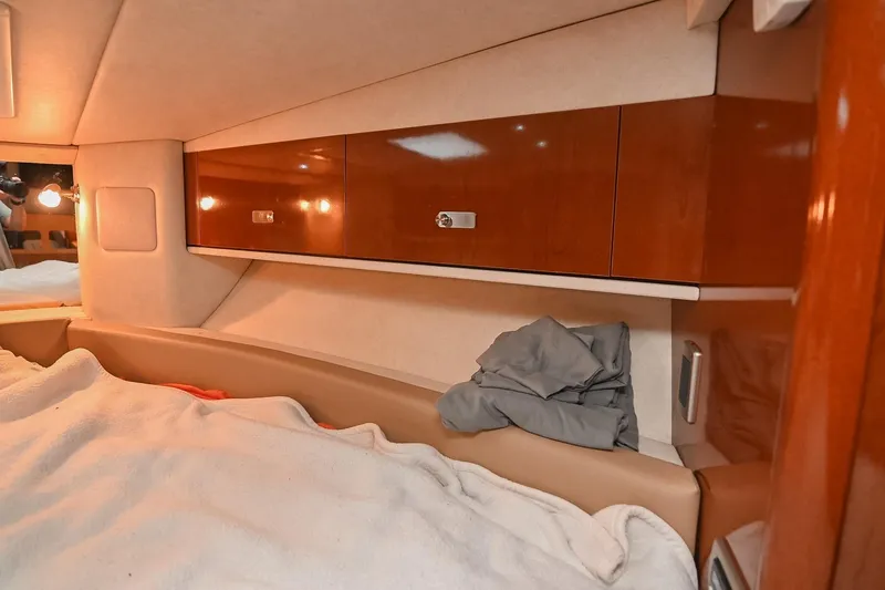 Slide: The Image of 2012 Sea Ray Sundancer 330 cabin interior with wooden cabinetry and cozy bedding. - 43