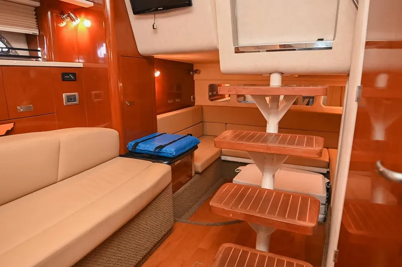 Slide: The Image of Interior of 2012 Sea Ray Sundancer 330 with beige seating and mounted TV. - 45