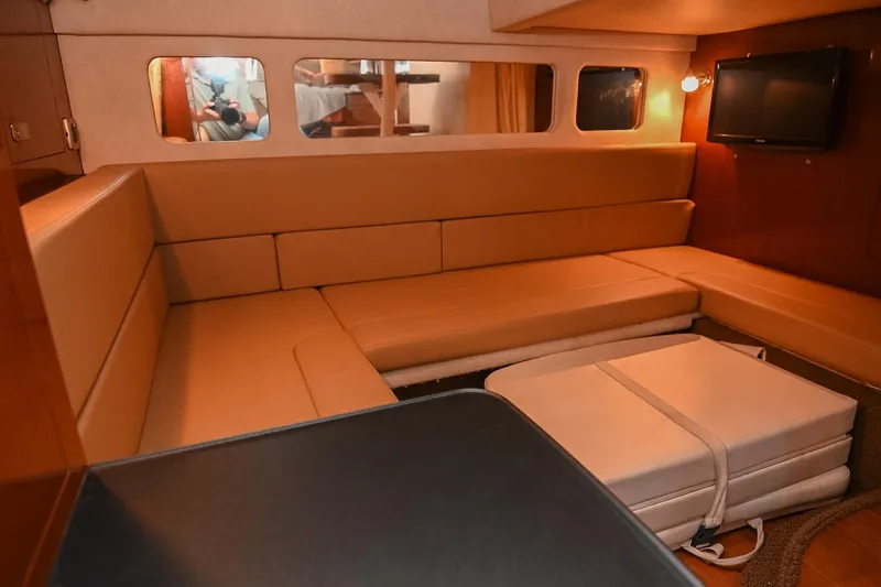 Slide: The Image of 2012 Sea Ray Sundancer 330 interior with beige seating and wooden accents. - 46