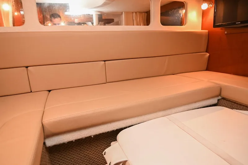 Slide: The Image of Interior of 2012 Sea Ray Sundancer 330 with beige seating and wall-mounted TV. - 48