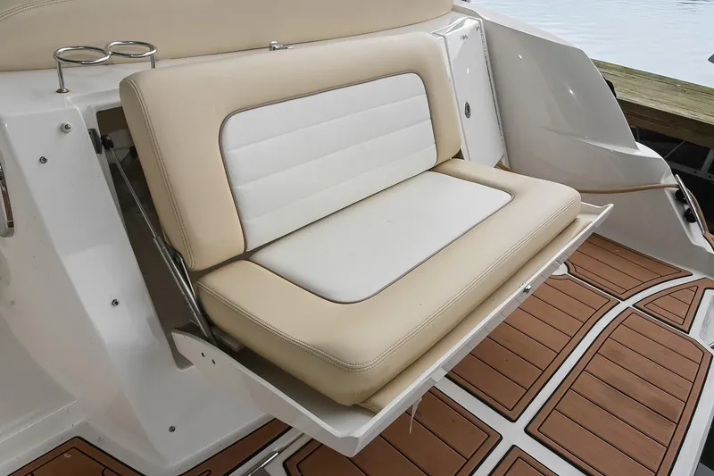 Slide: The Image of 2012 Sea Ray Sundancer 330 interior with seating and helm, docked at marina. - 8