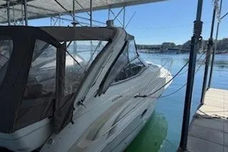 Slide: The Image of 2003 Doral 310se boat docked in a marina under a canopy. - 4