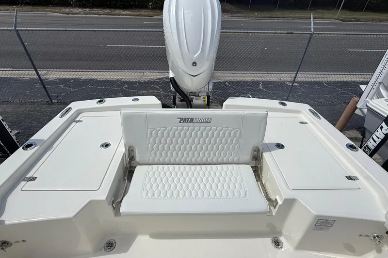 Slide: The Image of 2026 Pathfinder 2600 TRS boat interior with white seating and engine view. - 13