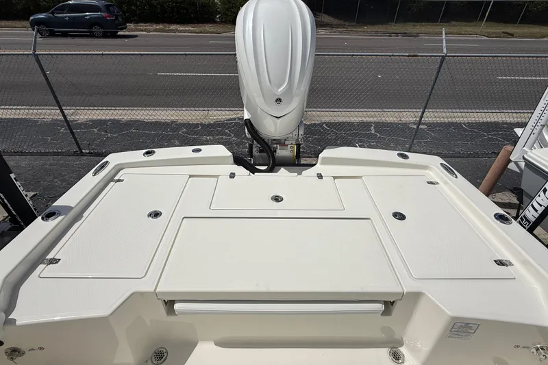 Slide: The Image of 2026 Pathfinder 2600 TRS boat deck with outboard motor, parked near a road. - 14