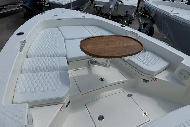 Slide: The Image of 2026 Pathfinder 2600 TRS boat interior with cushioned seating and wooden table. - 9