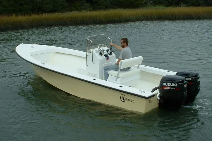 Slide: The Image of Manufacturer Provided Image: 2026 C-Hawk 23 Center Console boat with dual Suzuki engines on a calm waterway. - 2