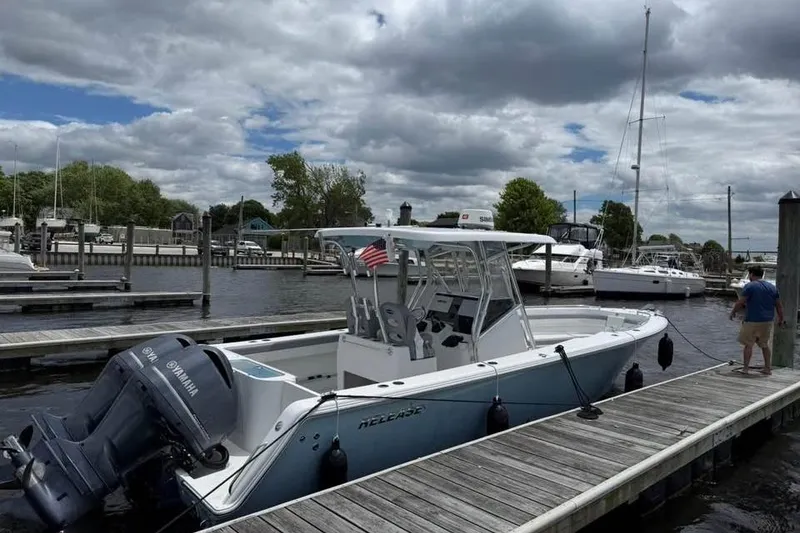 Slide: The Image of 2020 Release 301 RX boat docked at marina with Yamaha engines, under cloudy sky. - 2