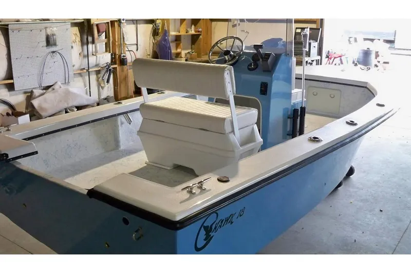 Slide: The Image of Manufacturer Provided Image: 2026 C-Hawk 18 Center Console boat in a garage, featuring a blue and white design. - 3