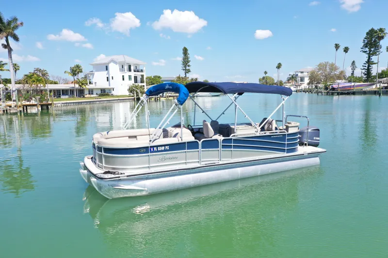 Slide: The Image of 2015 Berkshire 250E Premium pontoon boat on calm water, under a clear blue sky. - 0