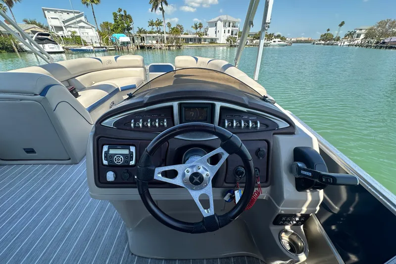 Slide: The Image of Steering console of a 2015 Berkshire 250E Premium pontoon boat on a sunny day. - 16
