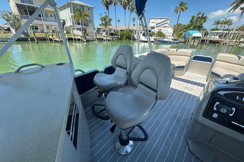 Slide: The Image of 2015 Berkshire 250E Premium pontoon boat interior with plush seating and scenic waterfront view. - 20