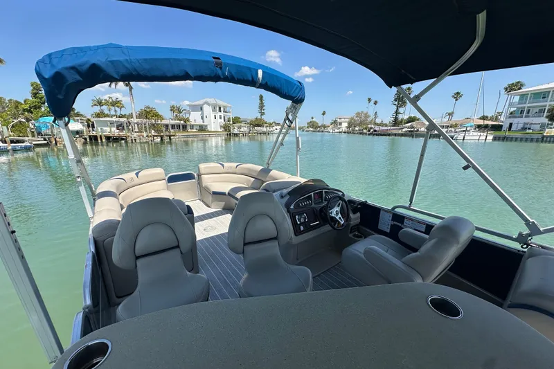Slide: The Image of 2015 Berkshire 250E Premium pontoon boat on serene water with blue canopy. - 21