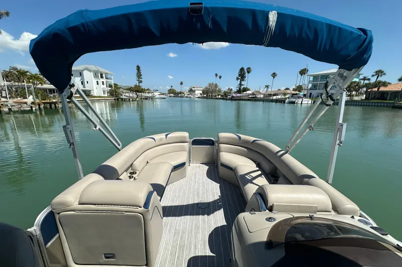 Slide: The Image of 2015 Berkshire 250E Premium pontoon boat on a serene waterway with blue canopy. - 9