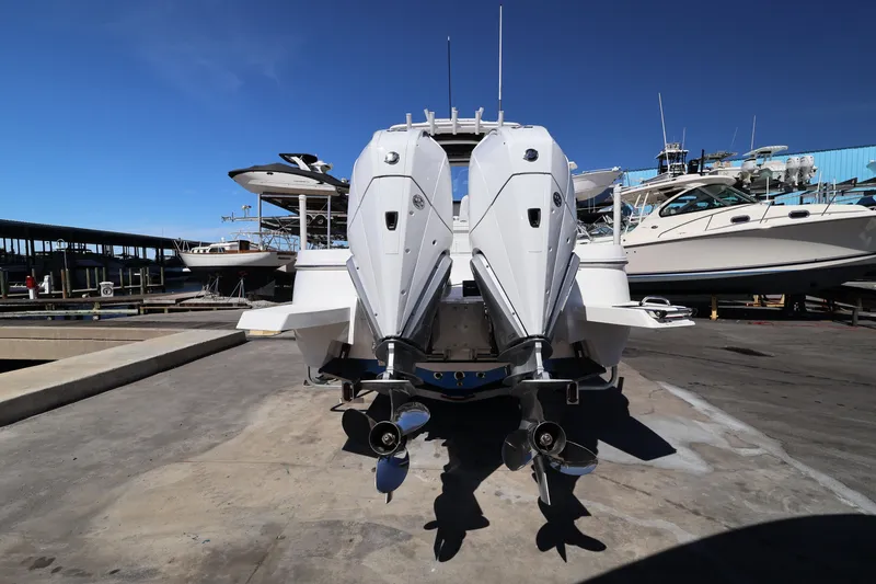 Slide: The Image of 2026 Caymas 291 boat with dual outboard motors at a marina dock. - 12