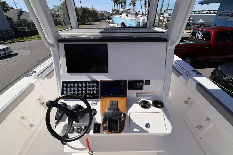 Slide: The Image of 2026 Caymas 291 boat helm with steering wheel, control panel, and navigation screen. - 14