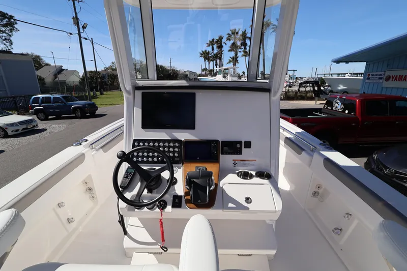 Slide: The Image of 2026 Caymas 291 boat cockpit with steering wheel, control panel, and display screen. - 15