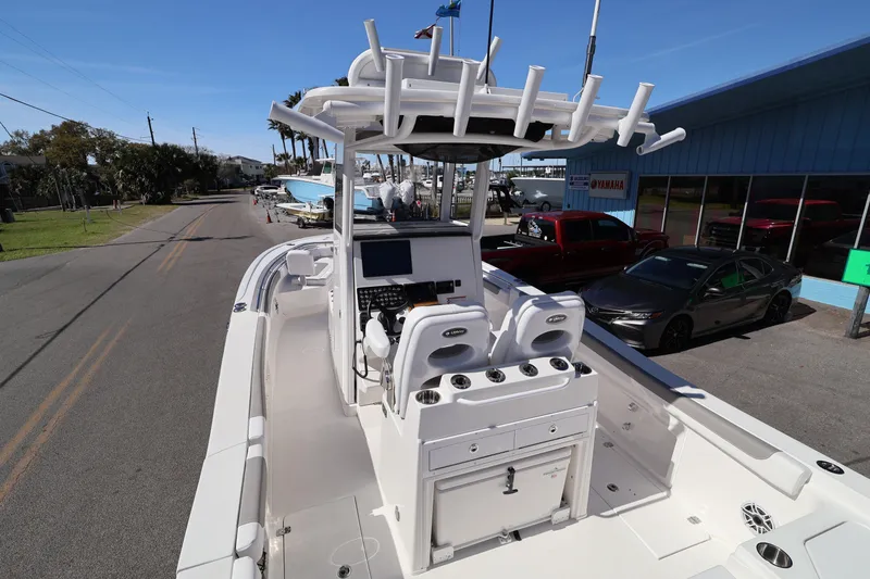 Slide: The Image of 2026 Caymas 291 boat with center console and rod holders, parked on a street. - 26
