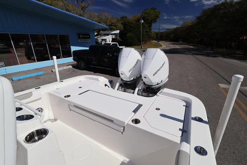 Slide: The Image of 2026 Caymas 291 boat with dual Mercury engines parked near a blue building. - 28