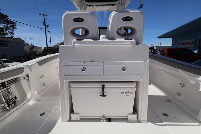 Slide: The Image of 2026 Caymas 291 boat interior with storage and seating, featuring a Frigid Rigid cooler. - 32
