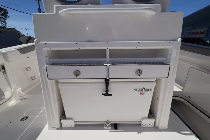 Slide: The Image of 2026 Caymas 291 boat interior with storage compartments and Frigid Rigid cooler. - 33
