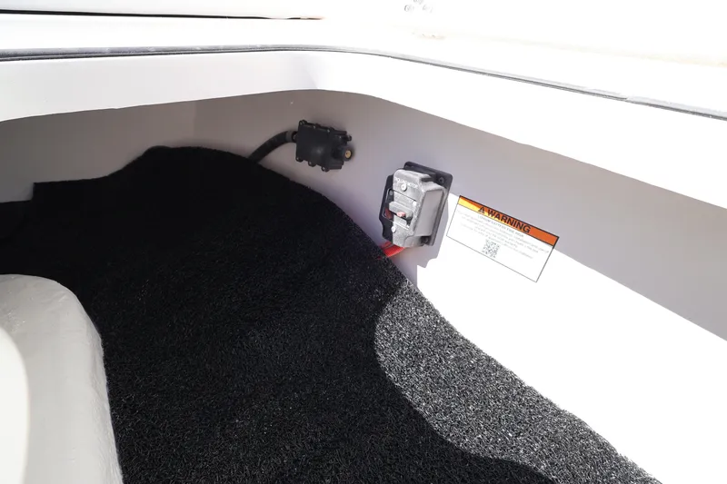 Slide: The Image of Interior view of 2026 Caymas 291 boat compartment with warning label and wiring. - 38
