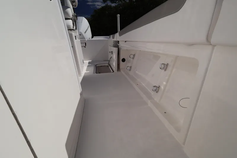 Slide: The Image of 2026 Caymas 291 boat interior, showcasing sleek white deck and storage compartments. - 43