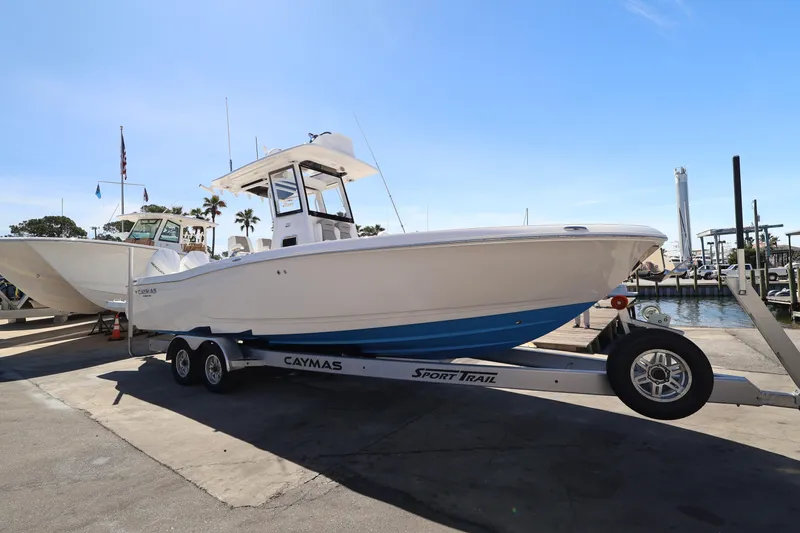 Slide: The Image of 2026 Caymas 291 boat on trailer at marina under clear blue sky. - 7