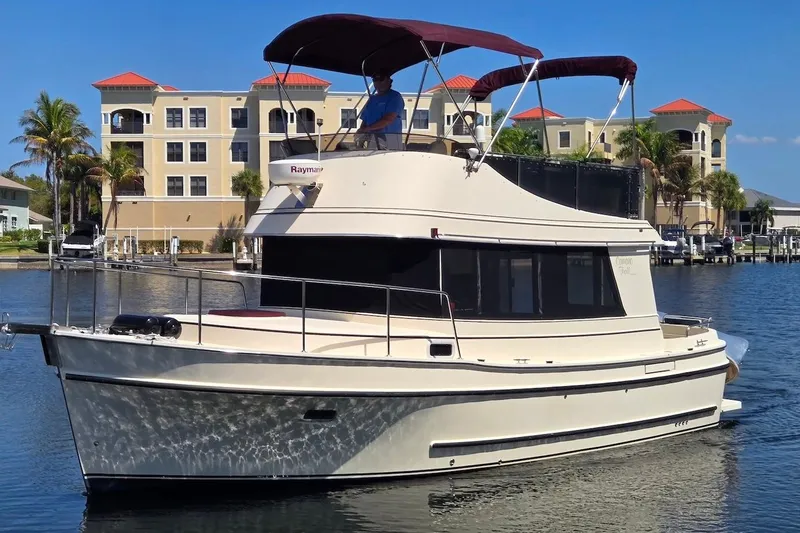 The Image of 2005 Camano 31 Troll boat on water, with buildings and palm trees in the background. - 0