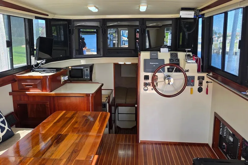 Slide: The Image of 2005 Camano 31 Troll boat interior with wooden finishes and navigation controls. - 19
