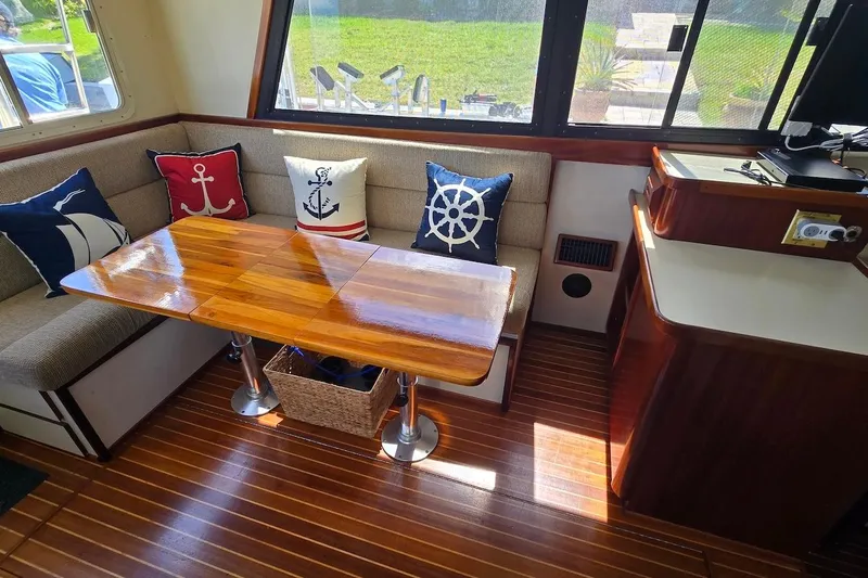 Slide: The Image of Interior of 2005 Camano 31 Troll boat with nautical-themed cushions and wooden table. - 20