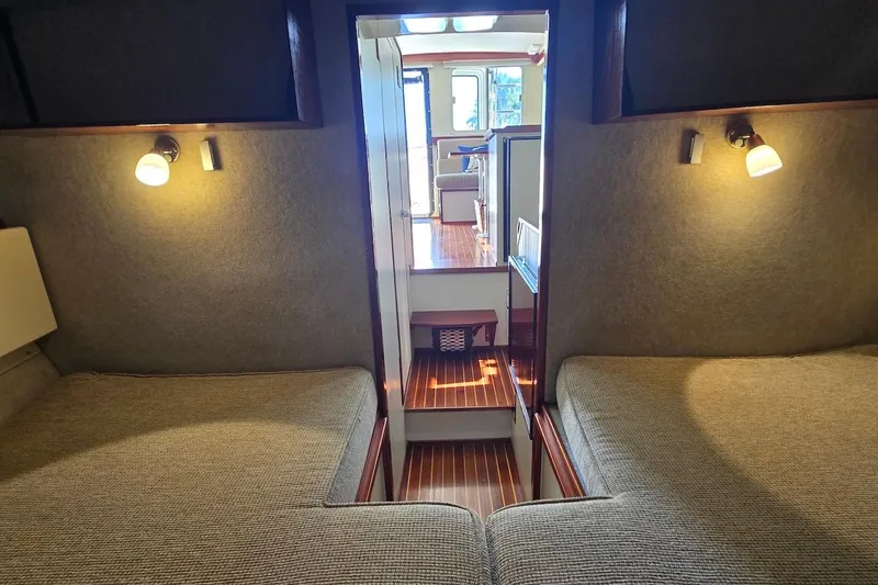 Slide: The Image of 2005 Camano 31 Troll interior cabin with cozy twin beds and warm lighting. - 25