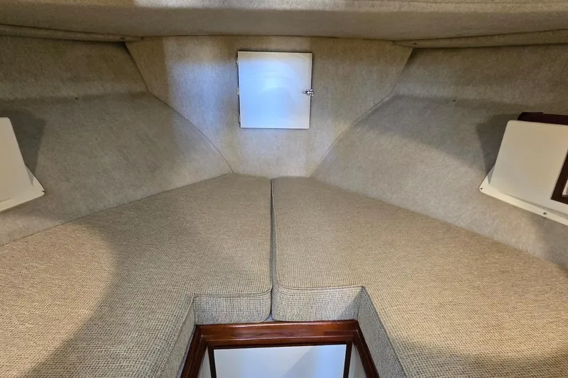 Slide: The Image of 2005 Camano 31 Troll interior cabin with beige upholstery and storage compartment. - 26