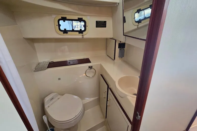 Slide: The Image of 2005 Camano 31 Troll boat bathroom with toilet, sink, and porthole window. - 27