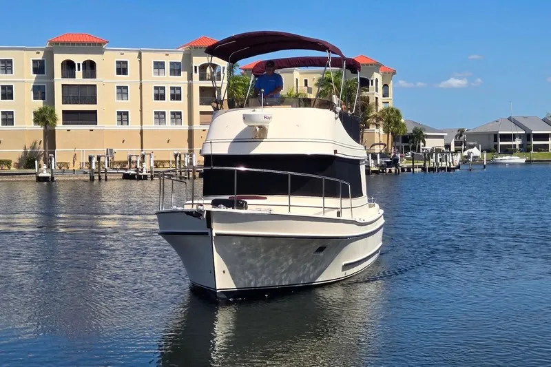 Slide: The Image of 2005 Camano 31 Troll boat cruising near waterfront buildings on a sunny day. - 5