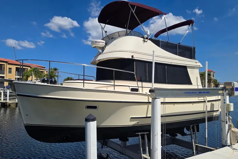 Slide: The Image of 2005 Camano 31 Troll boat on lift, featuring a canopy and Raymarine equipment. - 8