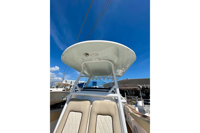 Slide: The Image of 2017 Seafox 288 Commander boat with T-top and cushioned seating under clear blue sky. - 15