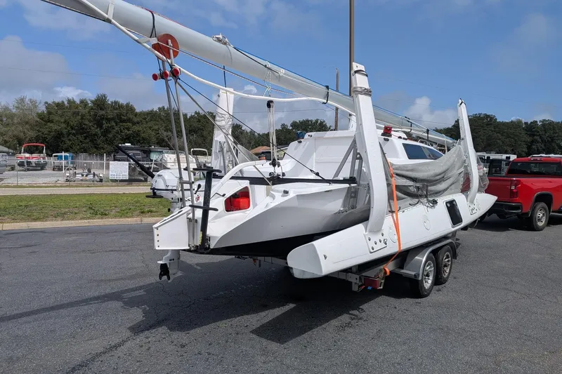 Slide: The Image of 2025 Corsair 760 sailboat on trailer, parked outdoors under a clear sky. - 5